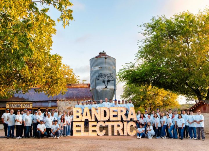 The Bandera Electric Cooperative team gathered by the grain silo at golden hour