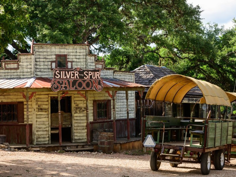 The Silver Spur Saloon exterior with a wagon parked under the live oaks