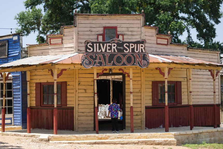 The front porch and hand-painted sign of the Silver Spur Saloon, doors open to the hall inside